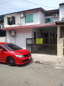 Kampong Telokkhairul homestay taman tengiri seberang jaya的停在房子前面的红色汽车