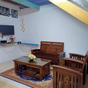 Kampong Telokkhairul homestay taman tengiri seberang jaya的客厅配有木制家具和桌子