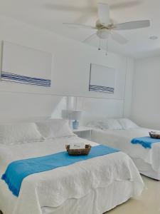 卡塔赫纳Hermoso apartamento en la playa的一间卧室配有两张床和吊扇