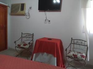 戈亚Las orquídeas的配有桌子和两把椅子以及电视的房间