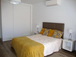 卢斯Belinha Guest House的一间卧室配有一张带黄色毯子的大床
