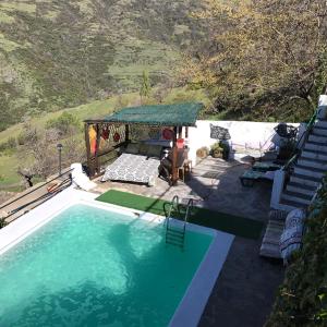 布维翁Cortijo "Casa Ibero" Bubion, Alojamiento Turistico Rural的游泳池旁设有凉亭