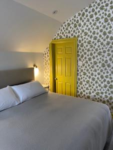 谢蒂坎普The Archie & Isidore Hotel的一间卧室设有一张床和一个黄色的门