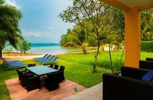 象岛维生素海别墅的一个带桌椅的庭院和一个海滩
