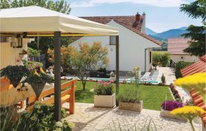 BajagićLovely Home In Bajagic With Kitchen的一个带白色遮阳伞和一些植物的庭院
