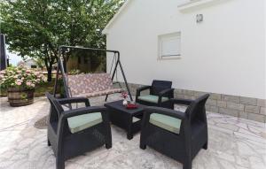 BajagićLovely Home In Bajagic With Kitchen的庭院里设有一组椅子和秋千