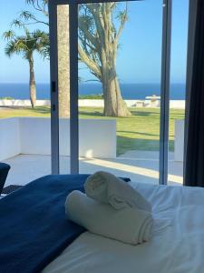 阿曼济姆托蒂Santorini Guesthouse的一间卧室设有一张床,享有海景