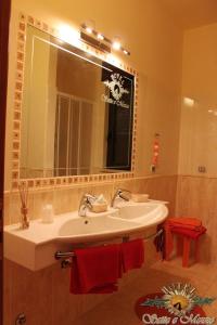 卡斯德鲁西苏比赛特梅佐酒店的浴室设有水槽、镜子和红色毛巾