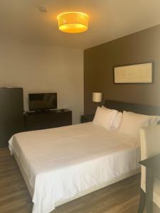 罗安达Casas de Luanda GH-Miramar的卧室配有白色的床和电视。