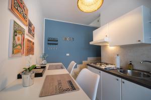 伯吉维奇Rif Holiday Home Stagnone Marsala的厨房配有水槽和带白色橱柜的桌子。