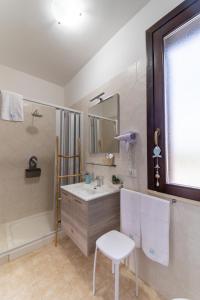 伯吉维奇Rif Holiday Home Stagnone Marsala的一间带水槽、镜子和椅子的浴室