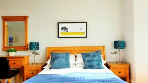 布莱顿霍夫看得见风景的房间酒店的一间卧室配有一张带蓝色枕头和镜子的床