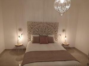 阿尔沃洛特APARTAMENTO ROMAR CHIC的一间卧室配有一张大床、两张桌子和吊灯。