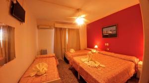 维拉卡洛斯帕兹Gran Lourdes Hotel by CPH的酒店客房,设有两张带红色墙壁的床