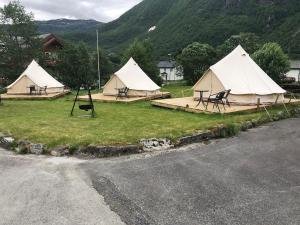 勒尔达尔希斯塔约能小屋酒店的草丛中一组配有桌椅的帐篷