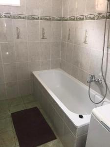 豪伊杜索博斯洛Gemini apartman的带淋浴的浴室配有白色浴缸。