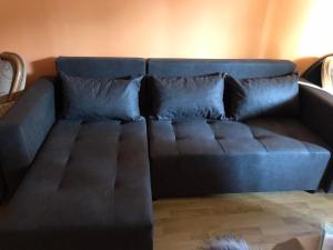 豪伊杜索博斯洛Gemini apartman的一张蓝色的沙发,配有两个枕头,位于房间里