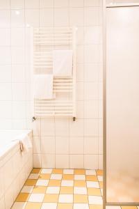福尔登巴克酒店的浴室设有白色瓷砖淋浴。