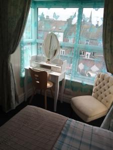 布里德灵顿斯科菲尔德宾馆 的一间卧室设有梳妆台、镜子和窗户。