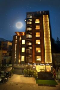 普塔帕蒂Sai Maa Hotel & Residency的一座高大的建筑,晚上有灯