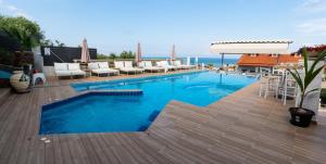 斯卡拉卡里拉奇斯Anny Residences & Suites的一个带椅子和甲板的大型游泳池