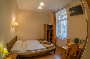 什恰夫尼察Jakubówka的一间卧室配有一张床、一张书桌和一个窗户。