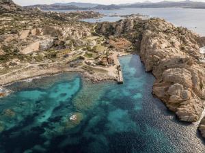 马达莱纳Residence Cala Francese - Case sul mare的享有蓝色海水岩石岛的空中景致