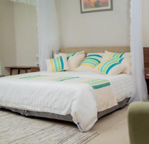 利隆圭Lalibela Boutique Hotel的一张带白色床单和枕头的床