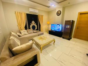 拉瓦尔品第Holidazzle Serviced Apartments Bahria Town的带沙发和电视的客厅