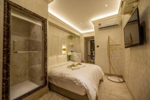 哥打京那巴鲁A Residence @ Between Hilton & Cititel Hotel的一间卧室设有一张床和一个步入式淋浴间。