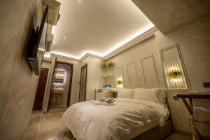 哥打京那巴鲁A Residence @ Between Hilton & Cititel Hotel的一间卧室配有一张带白色床单的大床