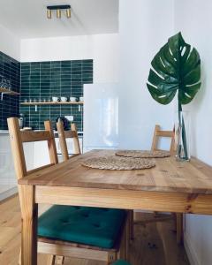格但斯克Apartament z Widokiem na Morze的一张带两把椅子的木桌和盆栽植物