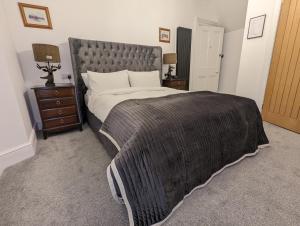 因弗内斯Cambeth Lodge的一间卧室配有一张带灰色毯子的大床