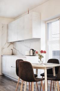 考纳斯Owls Hill Apartment的白色的厨房配有桌椅