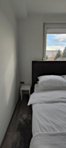 瓦拉日丁Perfect Place 33的白色的卧室设有床和窗户
