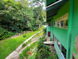 蒙泰韦尔德哥斯达黎加La Casa de la Montaña的一座带花园的绿色房子