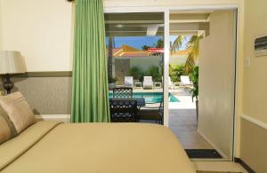 棕榈滩Yoyita Suites Aruba Villa的一间卧室配有一张床,享有游泳池的景色