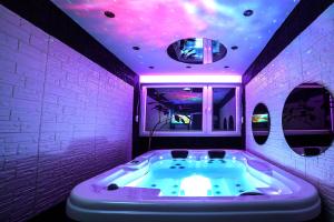 贝尔格莱德Aurora Lux Spa Smart apartments的紫色浴室设有紫色天花板和浴缸