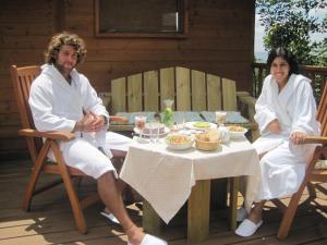 埃米瑞姆树林中的Spa - 阿米灵住宿加早餐旅馆的坐在餐桌旁吃饭的男人和女人