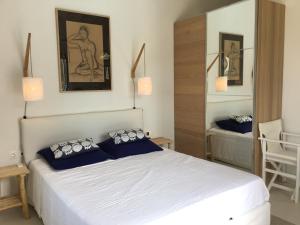 斯基亚索斯镇Luxury villa + guest house couchers de soleil mer的卧室配有带蓝色枕头的大型白色床