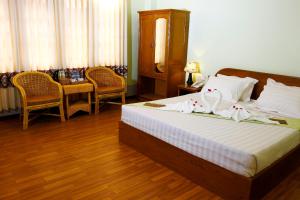 娘瑞檀香木酒店的卧室配有一张床和一张桌子及椅子