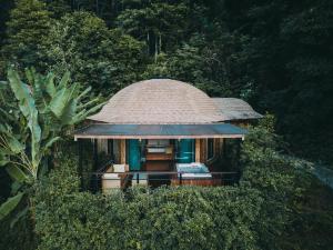 奥南海滩Aonang Fiore Resort - SHA Extra Plus的森林中带茅草屋顶的小房子