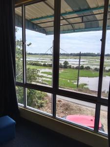 Pasir MasPutat Gajah Villa PASIR MAS的一间房间,窗户俯瞰着一个洪水泛滥的田野
