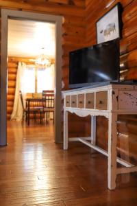拉皮德城Historic Log Cabin #14 at Horse Creek Resort的客厅配有桌子上方的电视