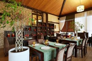 阿德勒Грейс Абрис的一间设有桌椅的餐厅,以及一间种植了植物的餐厅