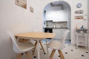 阿拉西奥appartamento fronte mare con terrazzo的厨房配有木桌和白色椅子