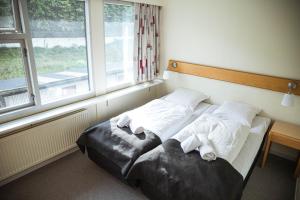 RunevigHotel Runavík的卧室在窗户前配有两张床