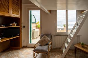 阿拉西奥Appartamento fronte mare con terrazzo zio的客厅设有楼梯、椅子和窗户