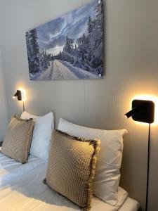 哈马尔Vikingskipet Hotell的卧室配有一张带两个枕头的床,墙上挂有绘画作品