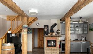 LīčiGuesthouse Sidrabozoli的厨房设有砖砌壁炉和木梁。
